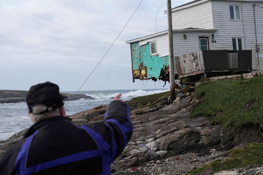 A person points towards a damaged house after the arrival of Hurricane Fiona in Port Aux Basques, Newfoundland, Canada September 25, 2022. REUTERS/John Morris     TPX IMAGES OF THE DAY